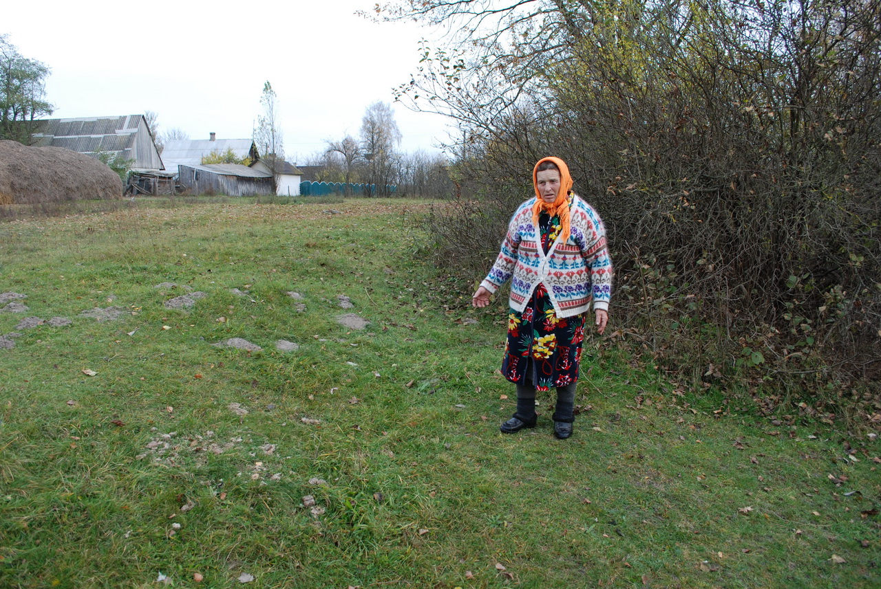 11. Софія Юрчук показує, де стояли малі хрести. Як розповіла жінка, що приїжджала з Польщі, саме тут вона поховала своїх дітей. Поруч, біля кущів, люди копали пісок.